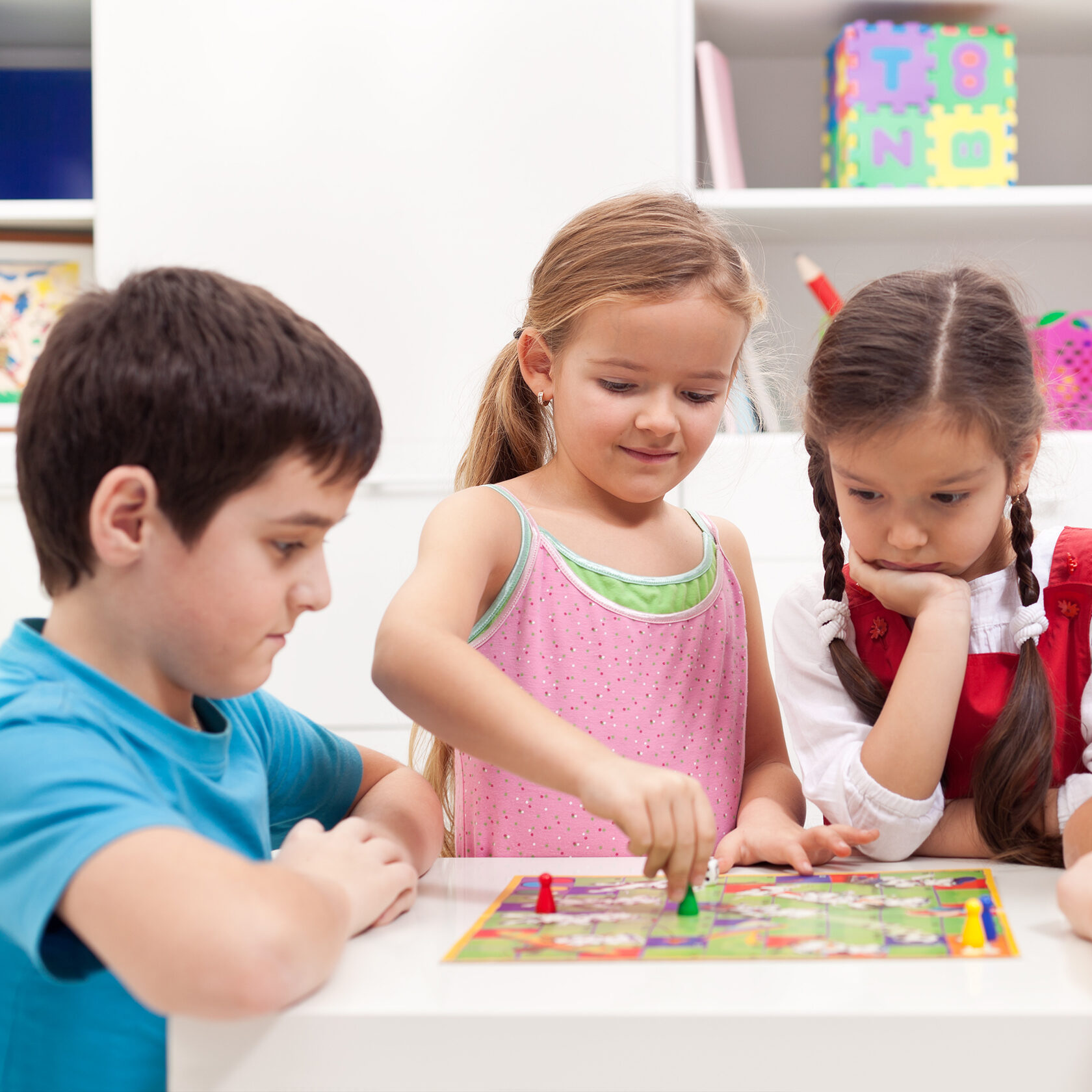 Children playing board game - sitting around a small table